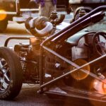 Detailed view of a customized high-performance car with exposed engine and roll cage.