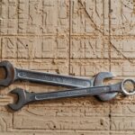 Two metal spanners placed on a textured wooden surface, showcasing industrial tools.